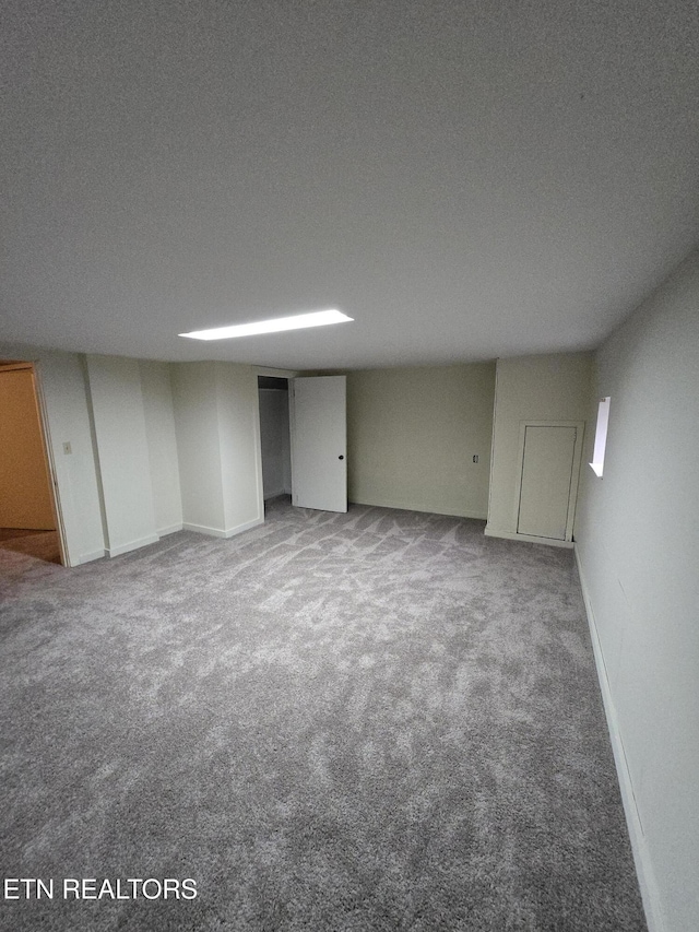 finished basement featuring baseboards and carpet floors