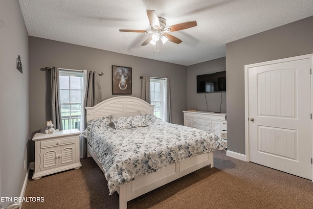 carpeted bedroom featuring ceiling fan and a textured ceiling