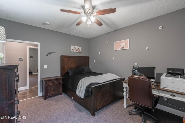 carpeted bedroom featuring ceiling fan and a textured ceiling