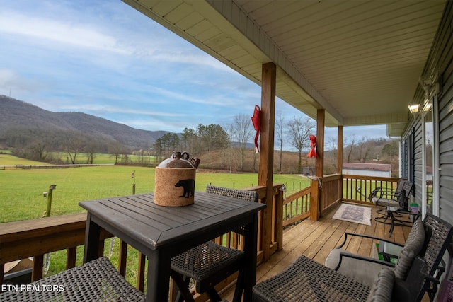 wooden deck with a lawn, a mountain view, and a rural view