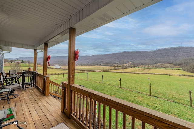 wooden deck featuring a mountain view, a rural view, and a yard