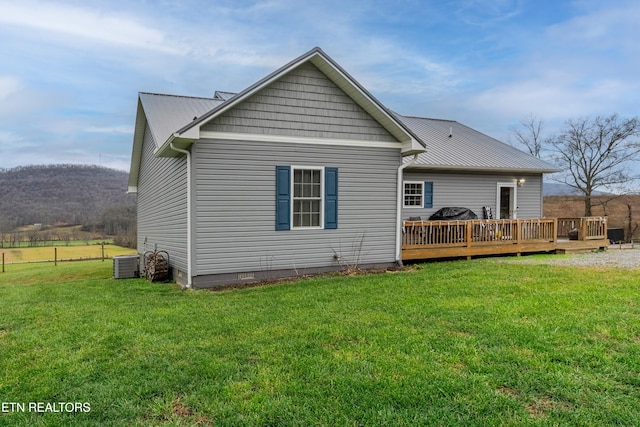 rear view of house with a lawn, cooling unit, and a deck with mountain view