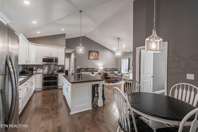 kitchen with appliances with stainless steel finishes, white cabinetry, ceiling fan, and dark wood-type flooring