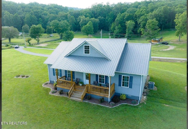 back of house featuring a lawn, covered porch, and central AC unit