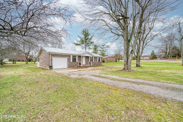 ranch-style house featuring a front yard and a garage