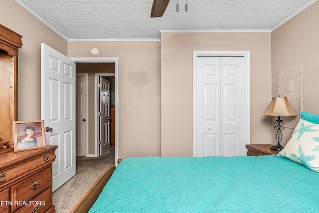 carpeted bedroom with a textured ceiling, a closet, ornamental molding, and ceiling fan