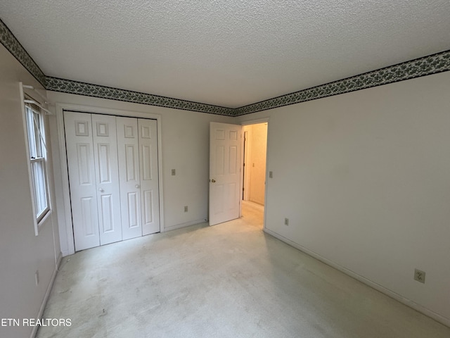 unfurnished bedroom with a textured ceiling and a closet