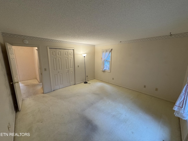 unfurnished bedroom with light carpet and a textured ceiling