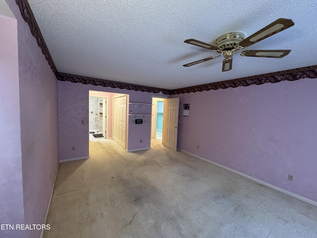 carpeted empty room with ceiling fan and a textured ceiling