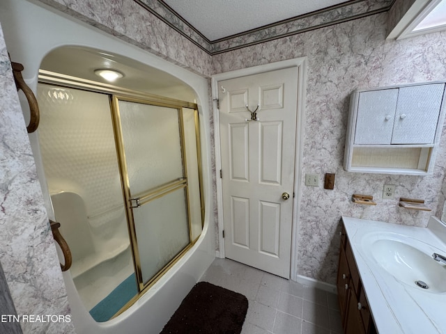 bathroom featuring vanity, a textured ceiling, and bath / shower combo with glass door