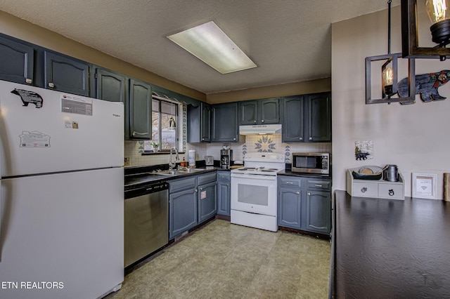 kitchen with a textured ceiling, sink, stainless steel appliances, and tasteful backsplash