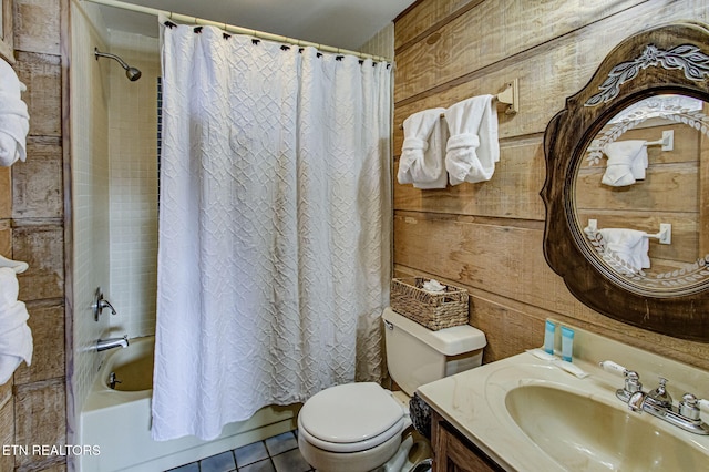 full bathroom with shower / tub combo, vanity, wooden walls, tile patterned flooring, and toilet