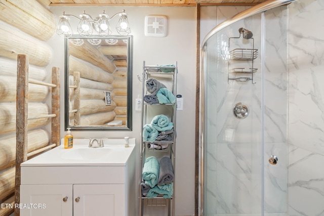 bathroom featuring vanity, a shower with door, and rustic walls