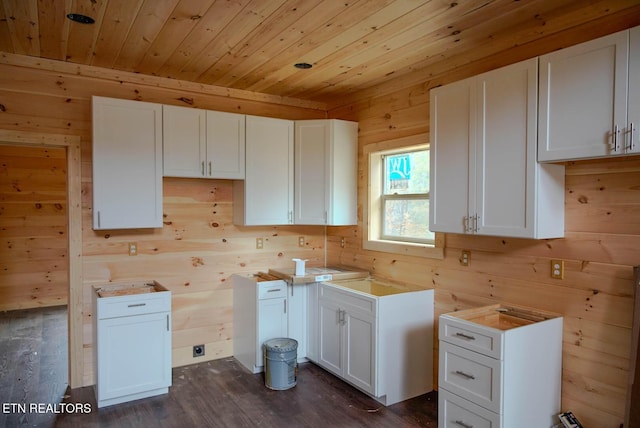 kitchen with white cabinetry, dark hardwood / wood-style flooring, wooden walls, and wooden ceiling