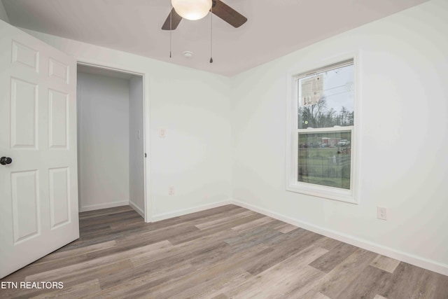 empty room with light hardwood / wood-style floors and ceiling fan