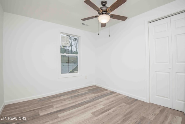 unfurnished bedroom featuring ceiling fan, light wood-type flooring, and a closet