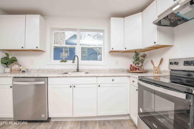 kitchen featuring white cabinetry, sink, stainless steel appliances, light hardwood / wood-style flooring, and range hood