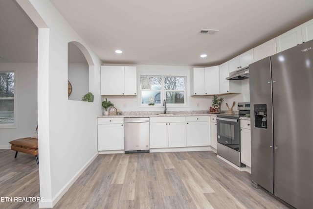 kitchen featuring stainless steel appliances, a healthy amount of sunlight, and light hardwood / wood-style floors