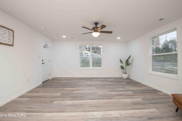 unfurnished room with ceiling fan, plenty of natural light, and light wood-type flooring