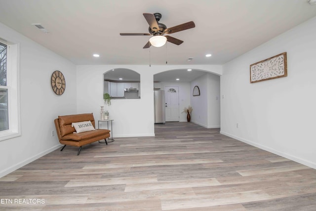 living area featuring light hardwood / wood-style flooring, a wealth of natural light, and ceiling fan