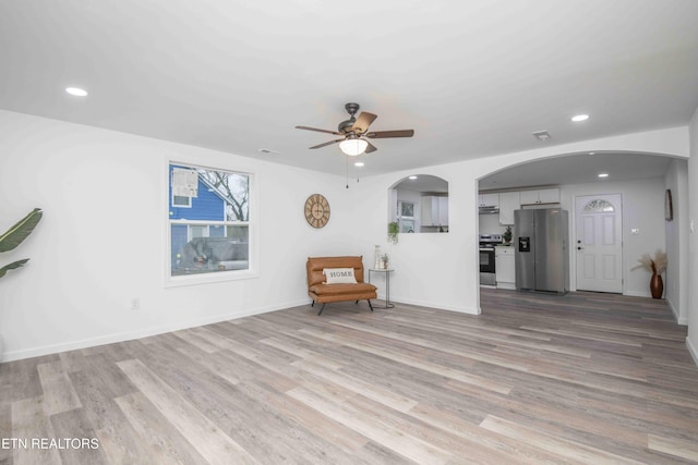 unfurnished living room featuring light hardwood / wood-style flooring and ceiling fan