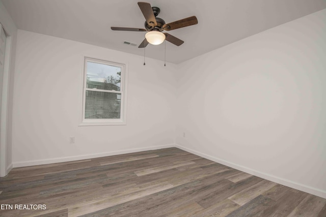 unfurnished room with ceiling fan and dark wood-type flooring