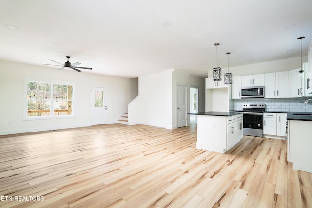 kitchen with ceiling fan, light hardwood / wood-style floors, decorative light fixtures, white cabinets, and appliances with stainless steel finishes