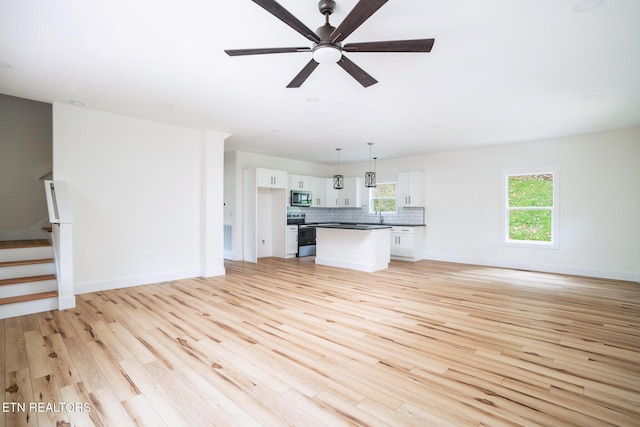 unfurnished living room with ceiling fan, sink, and light hardwood / wood-style flooring