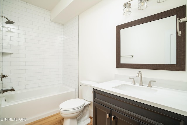 full bathroom with hardwood / wood-style floors, vanity, toilet, and tiled shower / bath combo