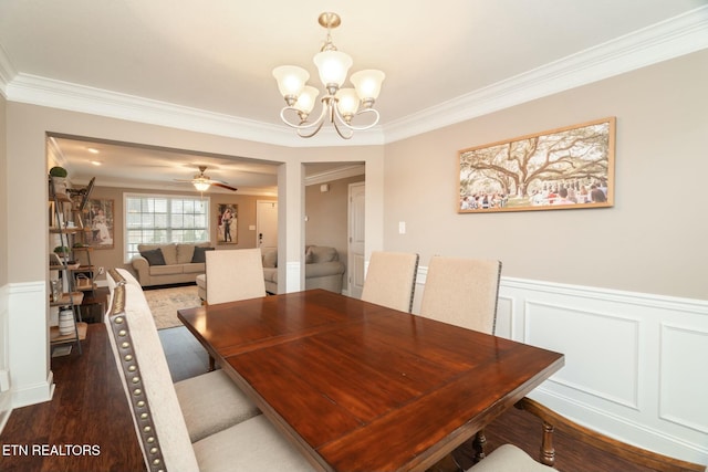 dining area featuring ceiling fan with notable chandelier, dark hardwood / wood-style flooring, and ornamental molding