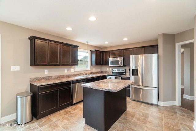 kitchen with appliances with stainless steel finishes, dark brown cabinets, sink, pendant lighting, and a center island