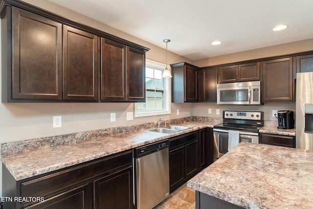 kitchen featuring pendant lighting, sink, dark brown cabinetry, and stainless steel appliances