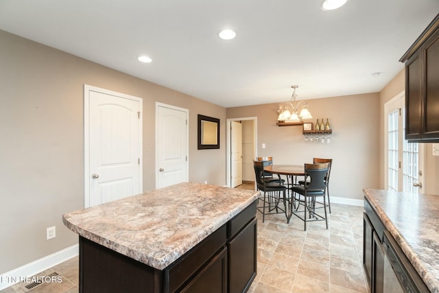 kitchen featuring dark brown cabinets, a center island, decorative light fixtures, and an inviting chandelier