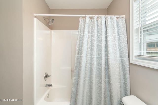 bathroom featuring shower / bath combo with shower curtain and a wealth of natural light