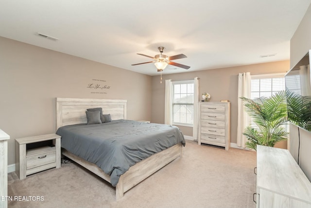 carpeted bedroom featuring multiple windows and ceiling fan