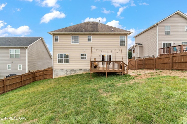 rear view of house featuring a wooden deck and a yard