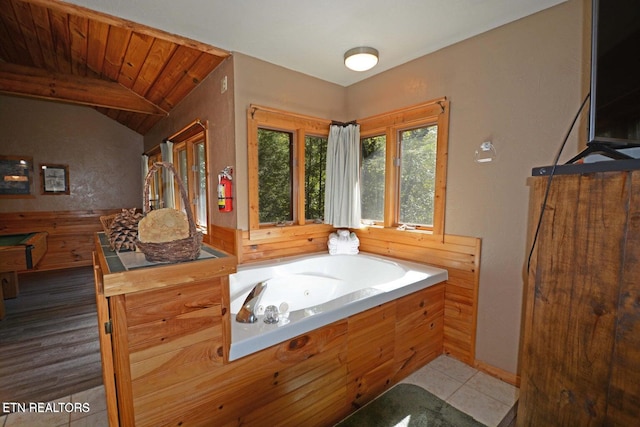 bathroom with tile patterned floors, a washtub, wood ceiling, and lofted ceiling