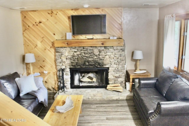 living room featuring wood walls and a fireplace