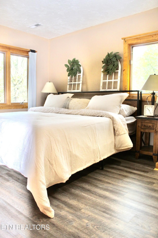bedroom featuring visible vents and wood finished floors