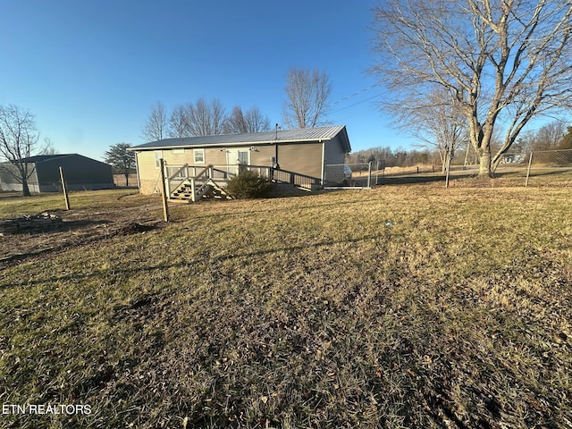 rear view of house with a wooden deck and a lawn