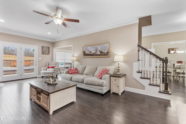 living room featuring baseboards, dark wood finished floors, ornamental molding, stairs, and ceiling fan with notable chandelier