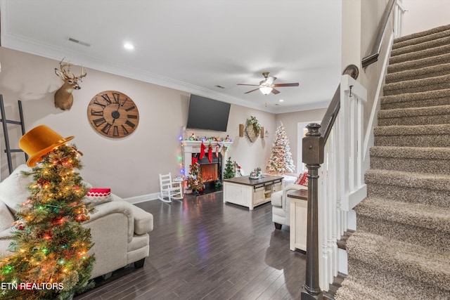 living room featuring visible vents, dark wood-style flooring, stairs, crown molding, and a fireplace