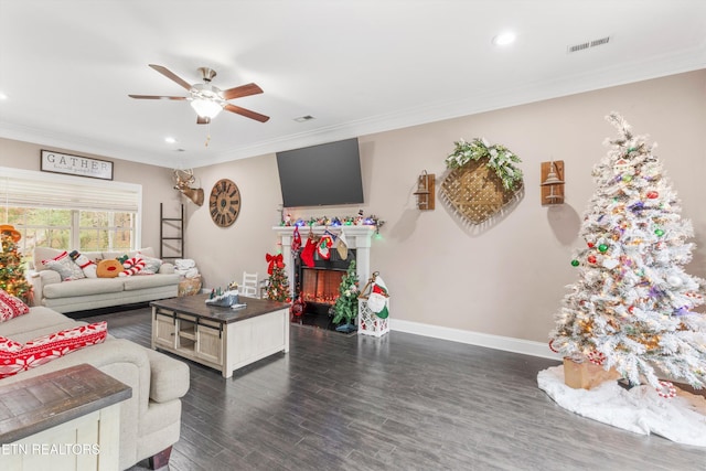 living area with crown molding, a fireplace, visible vents, and dark wood-style flooring