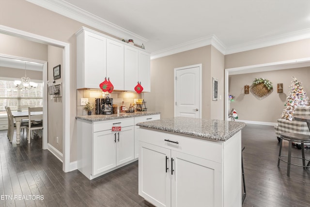 kitchen with a notable chandelier, white cabinetry, dark wood-style floors, tasteful backsplash, and crown molding