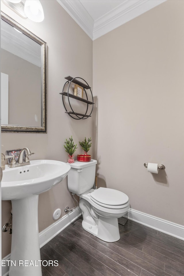 half bath featuring baseboards, wood finished floors, toilet, and crown molding