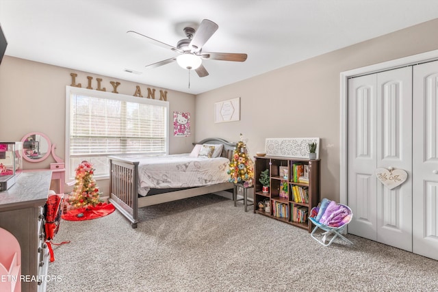 carpeted bedroom with a closet, visible vents, and a ceiling fan