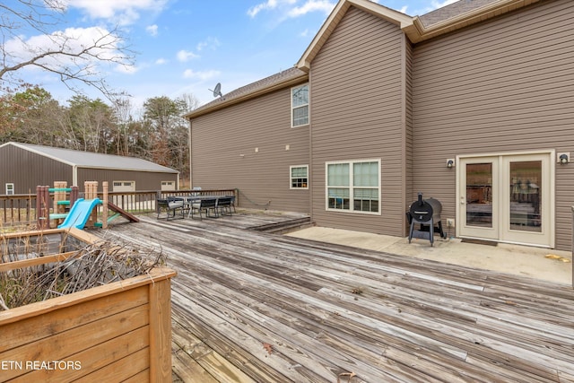 wooden deck with outdoor dining area and area for grilling