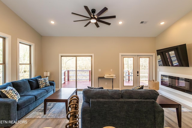 living room featuring french doors, vaulted ceiling, light hardwood / wood-style flooring, and ceiling fan