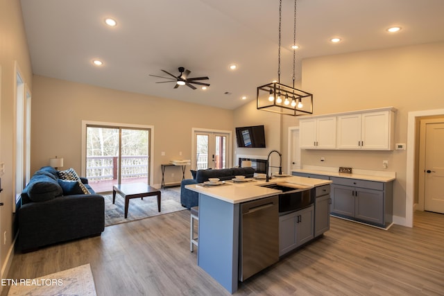 kitchen featuring ceiling fan, sink, a center island with sink, dishwasher, and white cabinetry