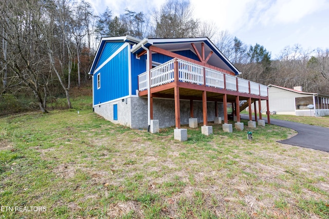 view of front of property featuring a front yard and a wooden deck